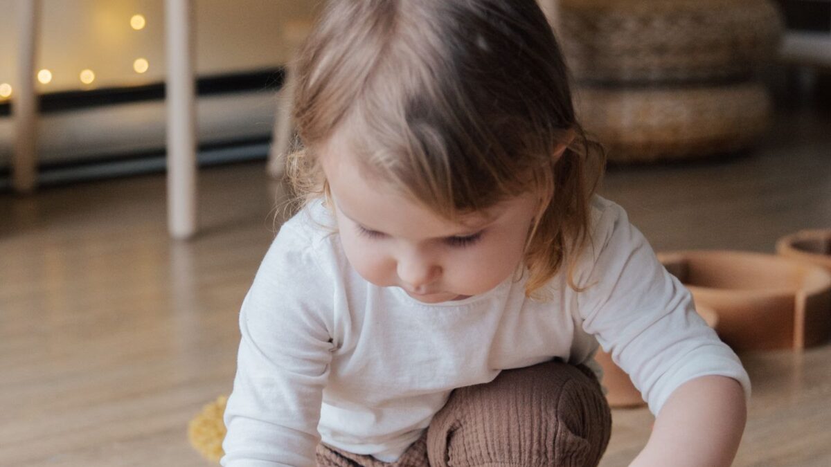 A two-year-old playing with wooden blocks at home - easy indoor activities for 2 year olds