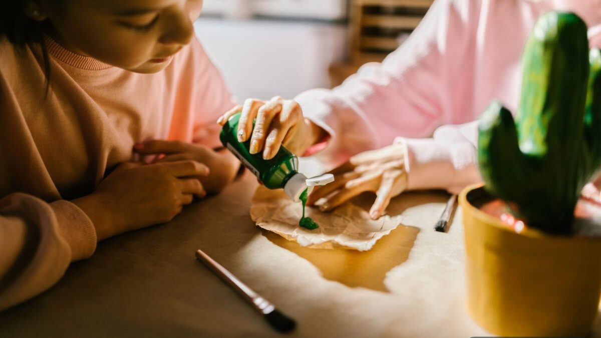 A preschooler painting at a craft table - learning and play activities for 3 year olds