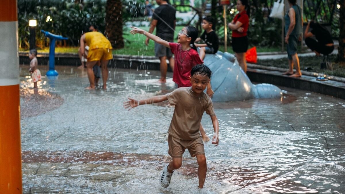 Children playing in water outdoors on a sunny summer day - summer activities for kids